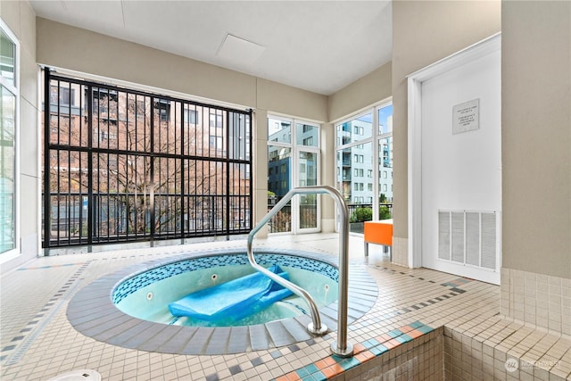 view of swimming pool featuring an indoor hot tub