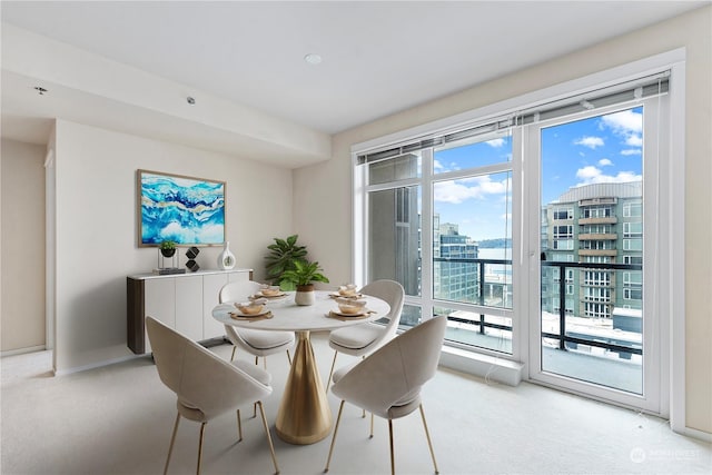 dining area featuring light colored carpet and a healthy amount of sunlight