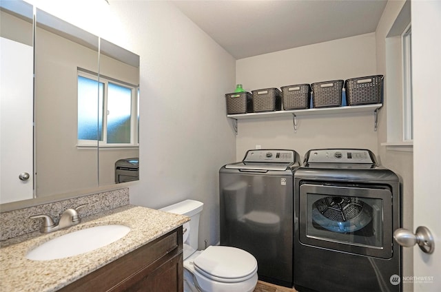 bathroom featuring vanity, toilet, and washing machine and clothes dryer