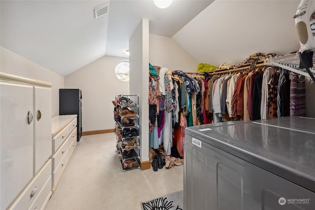 walk in closet with lofted ceiling and light carpet