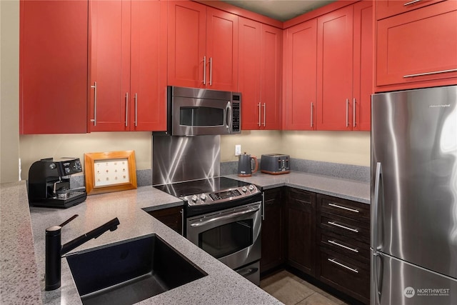 kitchen featuring light stone countertops, sink, and stainless steel appliances