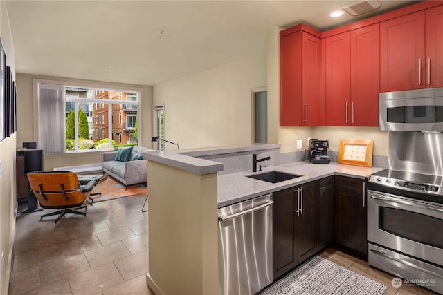 kitchen featuring sink, appliances with stainless steel finishes, kitchen peninsula, and light tile patterned flooring