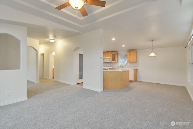 kitchen with pendant lighting, light brown cabinets, lofted ceiling, ceiling fan, and light colored carpet