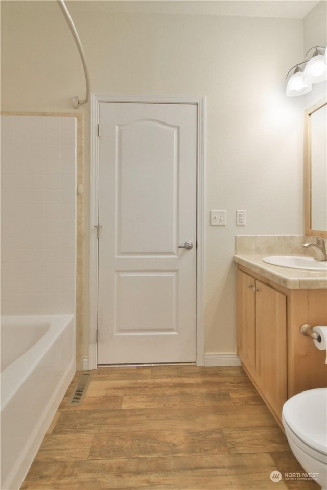 full bathroom with vanity, shower / bathtub combination, toilet, and wood-type flooring