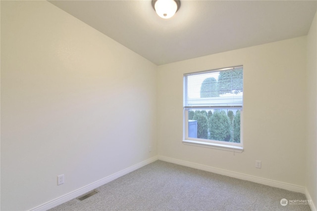 unfurnished room with carpet flooring and vaulted ceiling