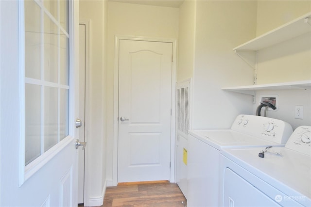 clothes washing area featuring washer and clothes dryer and dark hardwood / wood-style flooring