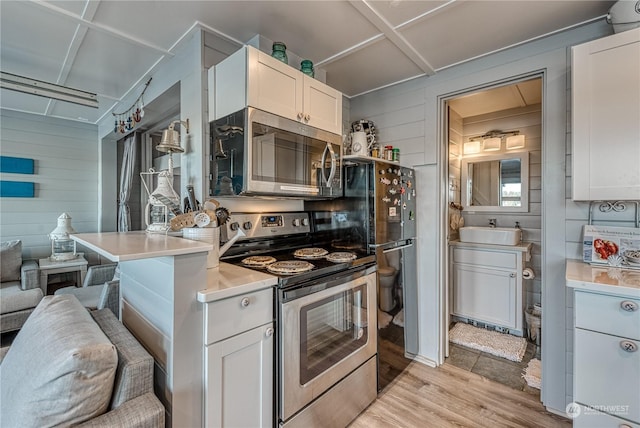 kitchen featuring white cabinets, light hardwood / wood-style floors, appliances with stainless steel finishes, and sink