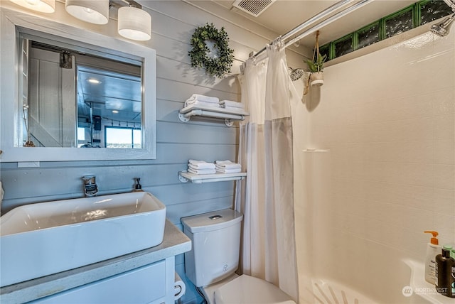 full bathroom with toilet, vanity, wood walls, and shower / bath combination with curtain