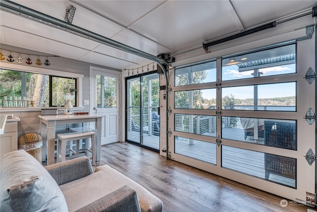 sunroom featuring a water view