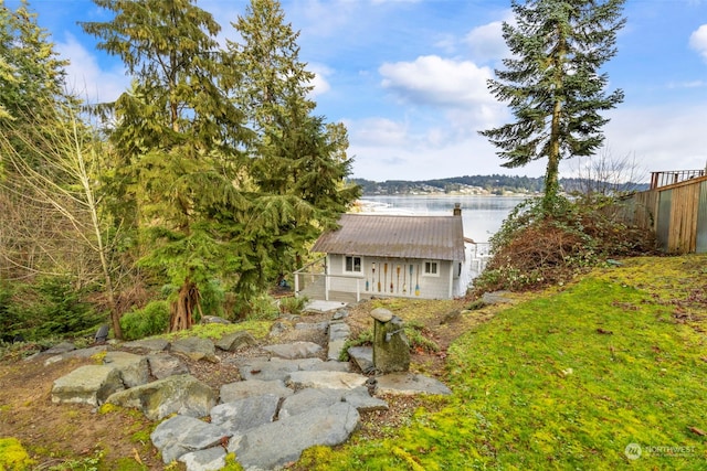 view of yard featuring a water view and an outdoor structure