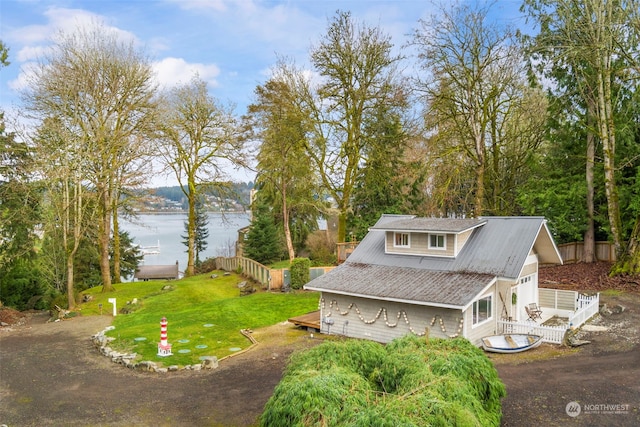 view of front of house with a front yard and a water view