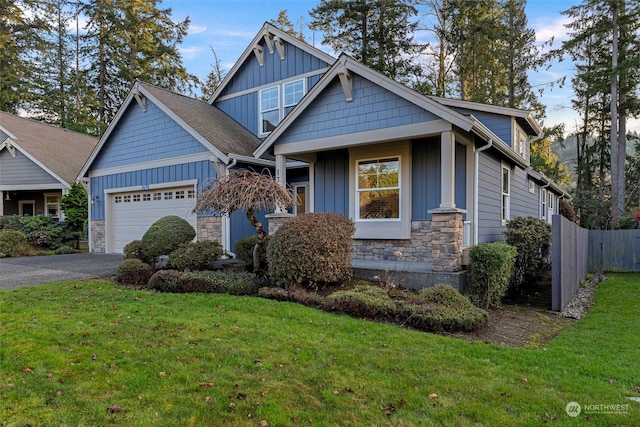 craftsman house with a garage and a front lawn