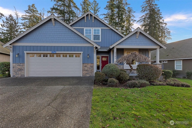 craftsman house featuring a front lawn and a garage