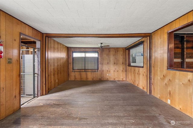 spare room with ceiling fan and wooden walls