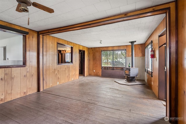 interior space with a wood stove and ceiling fan