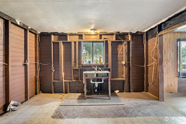 miscellaneous room with a textured ceiling and wooden walls