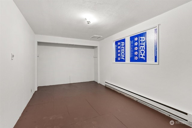 empty room with a textured ceiling and a baseboard radiator