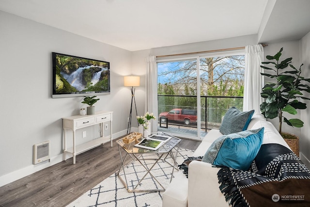 living room with heating unit and hardwood / wood-style flooring