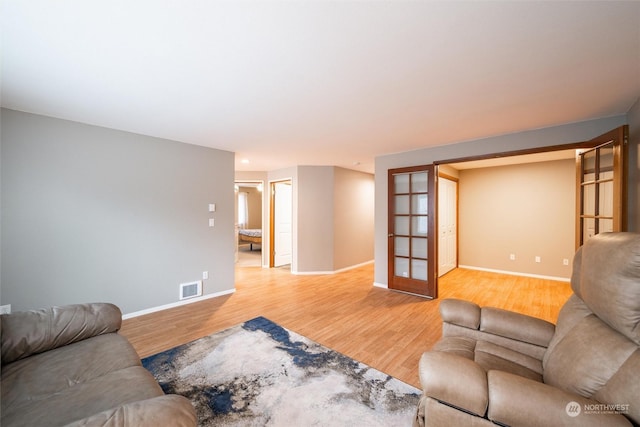 living room with french doors and light hardwood / wood-style floors