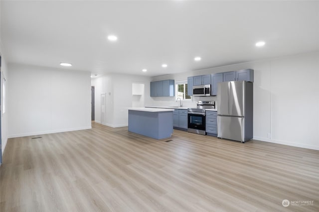 kitchen with a center island, sink, light wood-type flooring, and stainless steel appliances