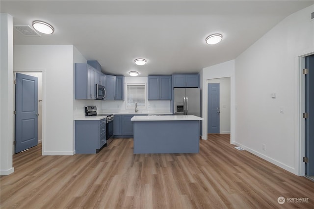 kitchen featuring sink, light hardwood / wood-style flooring, a center island, and appliances with stainless steel finishes