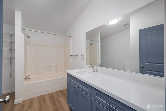 bathroom with hardwood / wood-style flooring, shower / tub combination, and vanity