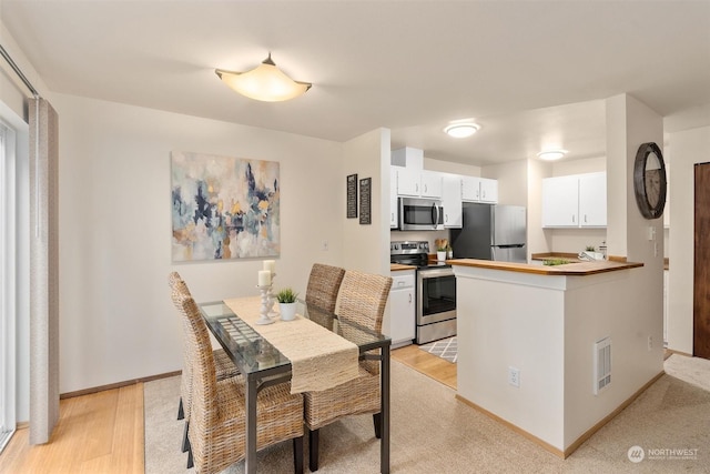 dining space with light hardwood / wood-style flooring