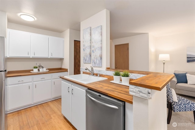 kitchen with sink, light hardwood / wood-style flooring, wooden counters, white cabinets, and appliances with stainless steel finishes