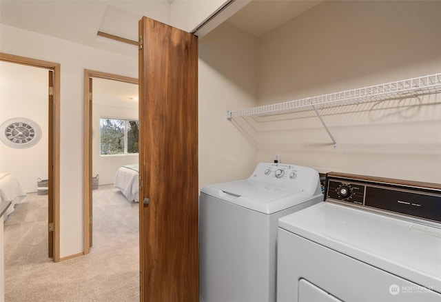 laundry room featuring washing machine and clothes dryer and light colored carpet