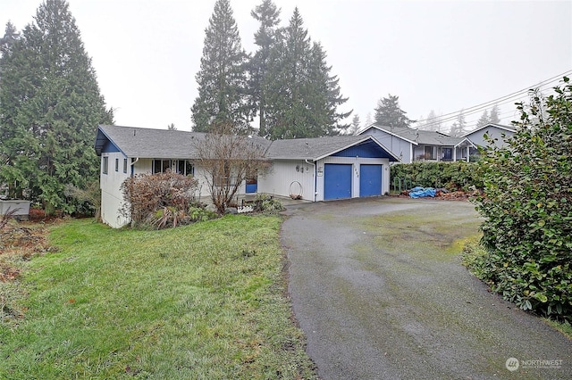 ranch-style home with a garage, a front lawn, and aphalt driveway