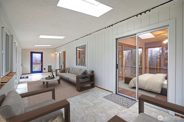 living room featuring a skylight and baseboards