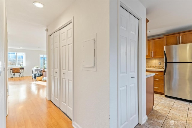 hall with light wood-type flooring and electric panel