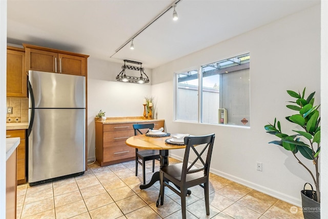 dining room featuring track lighting and light tile patterned flooring