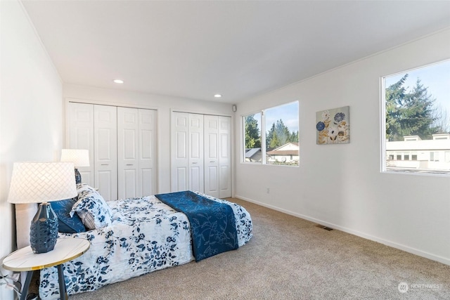 carpeted bedroom with multiple closets