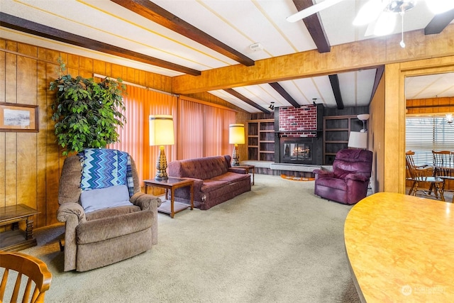 carpeted living room with wood walls, ceiling fan, and a brick fireplace