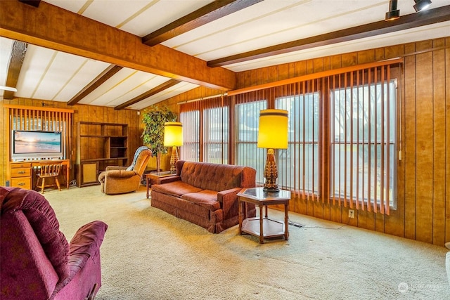 carpeted living room featuring wooden walls and lofted ceiling with beams