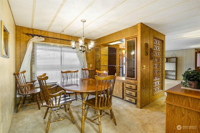 carpeted dining room with a notable chandelier and wooden walls