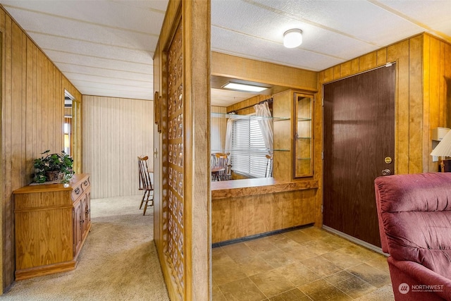 corridor with wood walls and light carpet