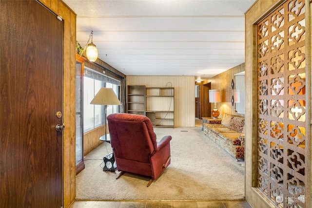 living room with light colored carpet and wooden walls