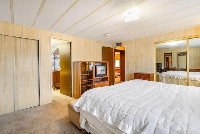 bedroom featuring wood walls and light colored carpet