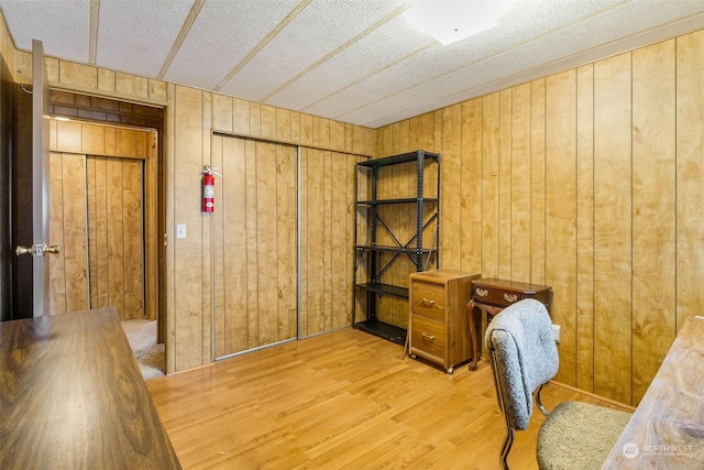 office space with wooden walls and hardwood / wood-style flooring