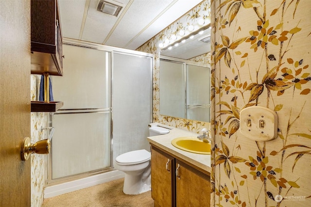 bathroom with vanity, a shower with shower door, a textured ceiling, and toilet