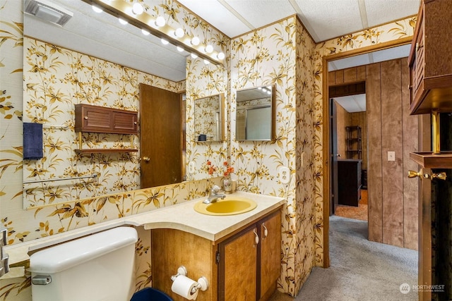 bathroom with vanity, toilet, and a textured ceiling