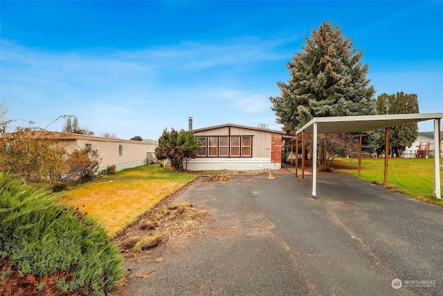 view of front of home featuring a carport and a front lawn