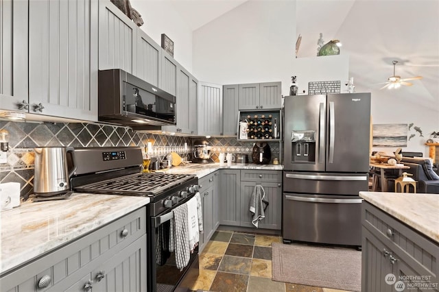 kitchen featuring gray cabinetry, high vaulted ceiling, and stainless steel appliances