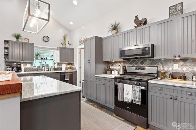 kitchen featuring gray cabinets, decorative backsplash, stainless steel appliances, and decorative light fixtures