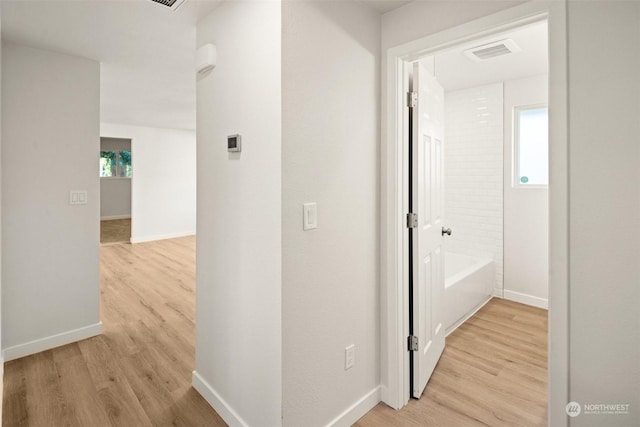 hall with a wealth of natural light and light wood-type flooring