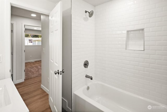 bathroom with tiled shower / bath combo, vanity, and hardwood / wood-style floors