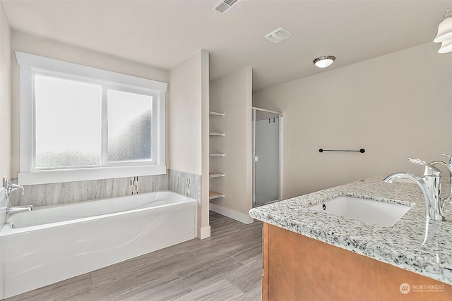 bathroom featuring vanity and shower with separate bathtub