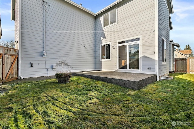 back of house featuring a patio and a lawn